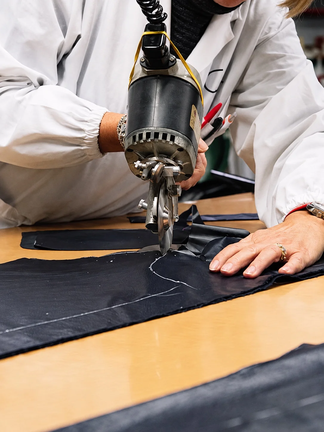 A hand examining the edge of burgundy shearling