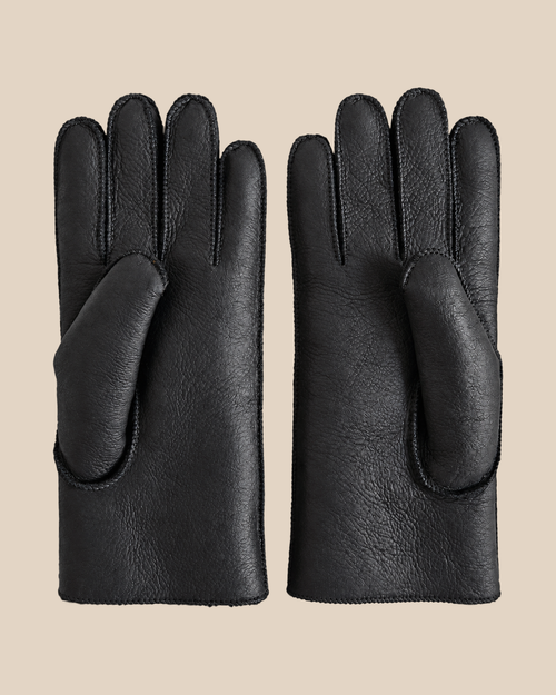 Nappa shearling gloves - black — product view 01, shearling gloves on a beige background